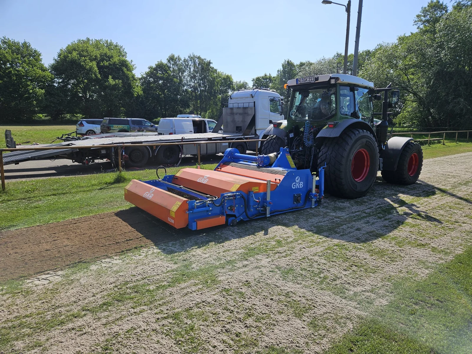 GKB-Bodenbearbeitungsgerät am Fendt-Traktor auf einer Sportplatzfläche.